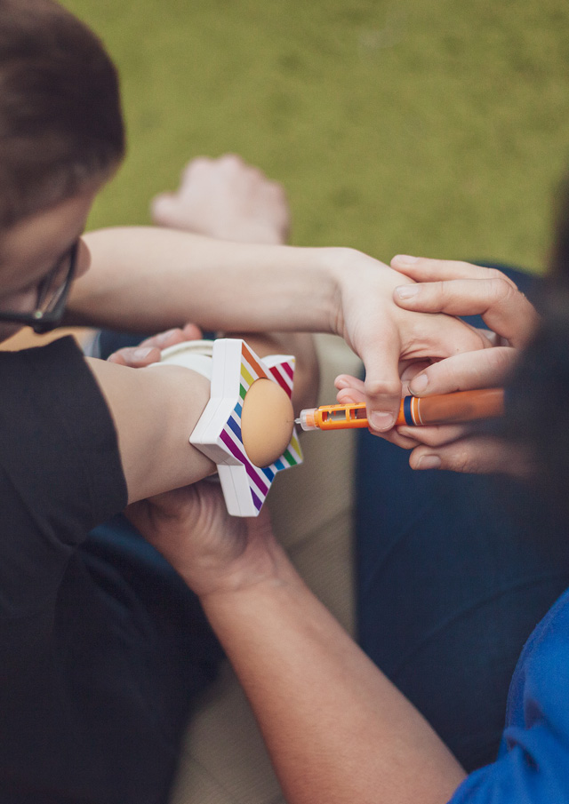 Child using a epipen with assistance from an adult. 